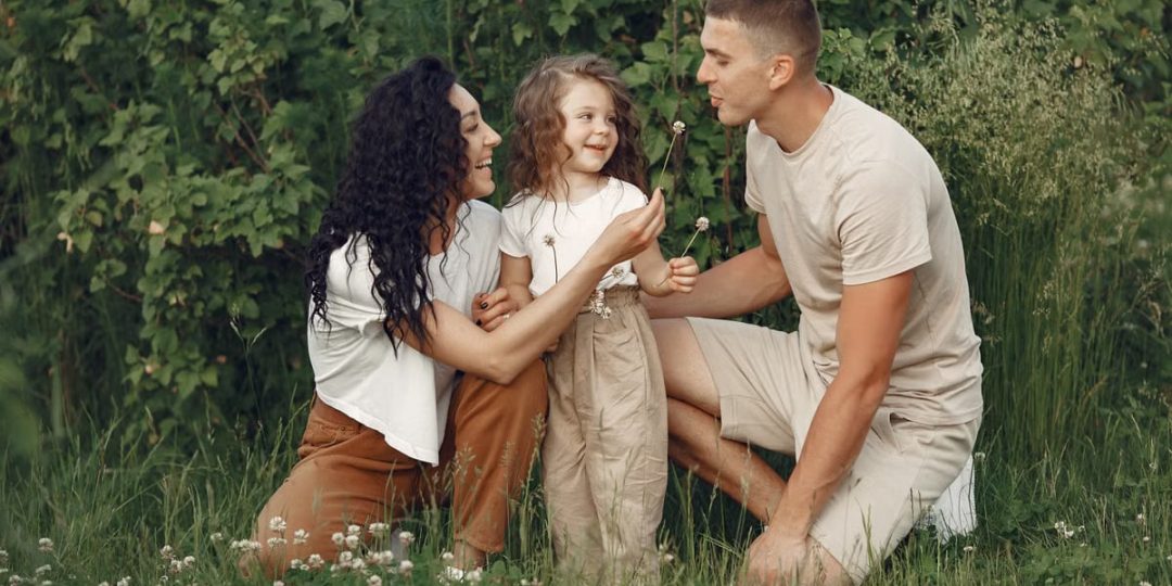A joyful family enjoying time together in a lush green meadow, capturing love and bonding.